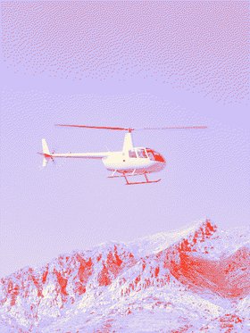 Helicopter flying past a snowy mountain.